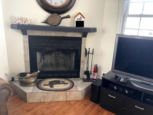 a living room with a fireplace and a clock on the wall at Mountain home in Newland in Newland