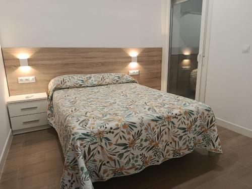 a bedroom with a bed with a floral bedspread at Llano 71 -B- in Archidona