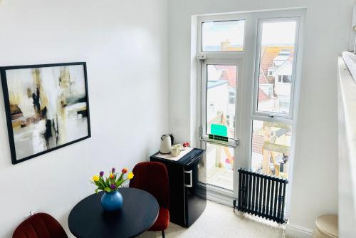 a living room with a table and a window at Reef Lodge in Newquay