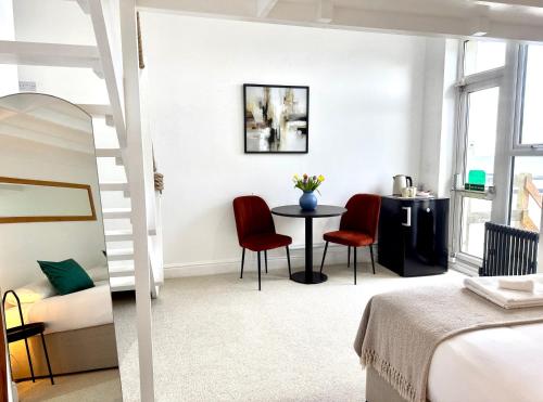 a bedroom with a bed and a table and chairs at Reef Lodge in Newquay