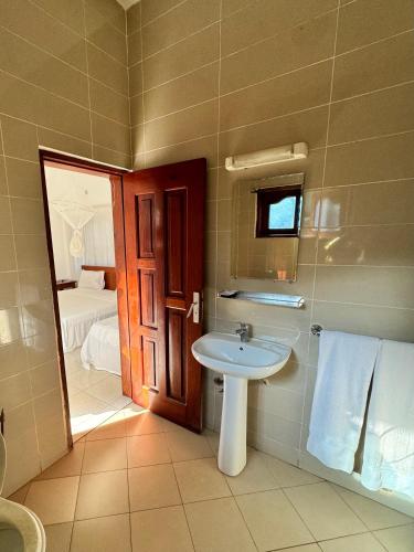 a bathroom with a sink and a room with a bed at Ramaya Auberge Espagnole in Grand-Popo