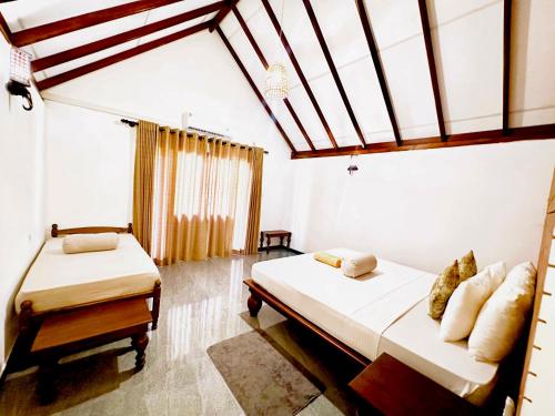 a bedroom with two beds and a skylight at Sigiriya Lahiru Homestay in Sigiriya