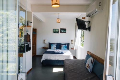 a bedroom with a bed and a couch at Vila Boa Vista Itacaré in Itacaré