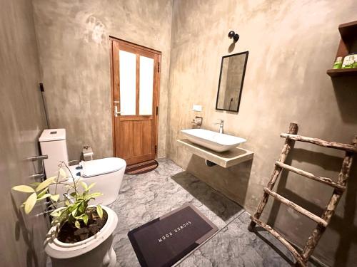 a bathroom with a sink and a toilet and a mirror at Sigiriya Lahiru Homestay in Sigiriya