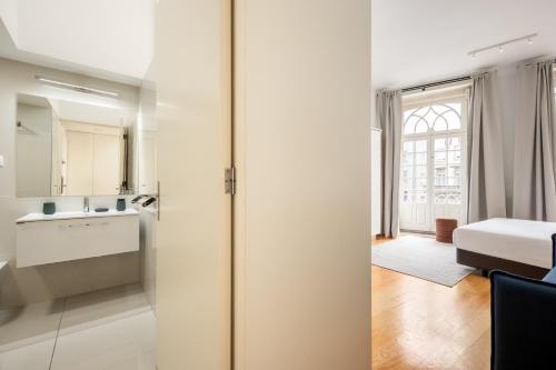 a kitchen and bathroom with a sliding glass door at Aspasios Trindade Apartments in Porto