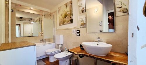 a bathroom with a sink and a toilet and mirrors at open space apt - comodo a Venezia in Treviso