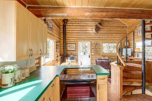a kitchen with wooden cabinets and a stove in a cabin at Wild Adventures in Eureka! Amish-Crafted Cabin in Eureka