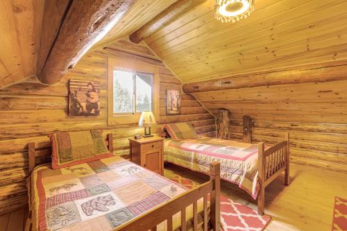 a bedroom with two beds in a log cabin at Wild Adventures in Eureka! Amish-Crafted Cabin in Eureka