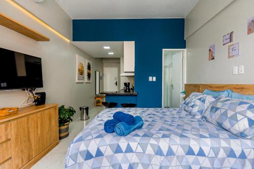 a bedroom with a blue and white bed and a television at Charme da Santa Clara in Rio de Janeiro