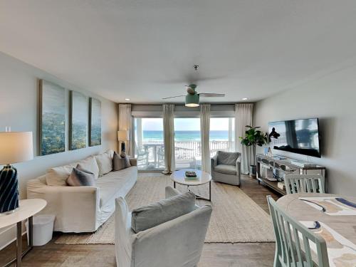 a living room with a white couch and a table at Commodores Retreat #205 in Santa Rosa Beach