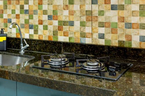 a kitchen stove with four pots and pans on it at Charme da Santa Clara in Rio de Janeiro