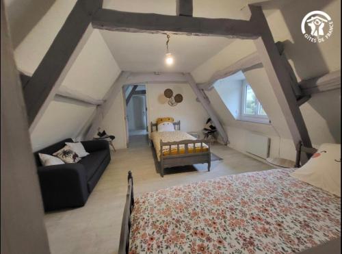 a attic bedroom with a bed and a couch at Au rucher in Fressin