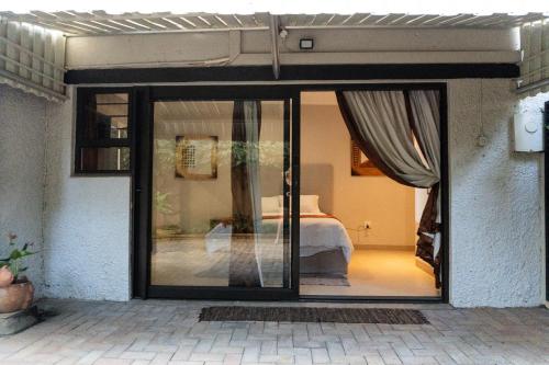 a room with a bed and a sliding glass door at Megs Guesthouse in Ballito