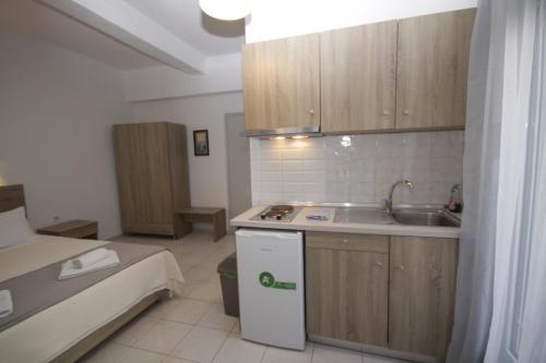 a small kitchen with a sink and a bed at PortoDream Studios & Apartments in Neos Marmaras