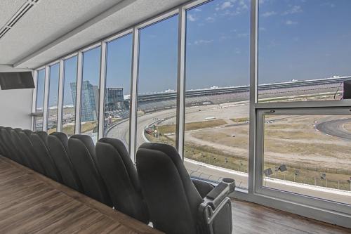 a conference room with chairs and a view of an airport at Shop and Dine Fort Worth Condo with Racetrack Views! in Fort Worth