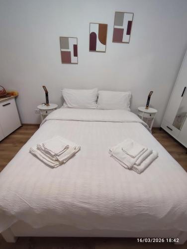 a white bed with two white towels on it at Transilvania Studio in Sibiu
