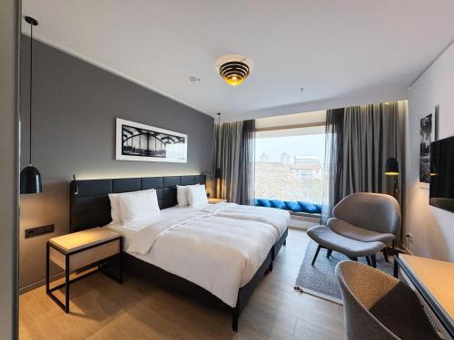 a hotel room with a large bed and a chair at Radisson Blu Hotel, Mannheim in Mannheim