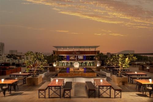 a rooftop patio with tables and a building at Radisson Blu Hotel, Dubai Barsha Heights in Dubai