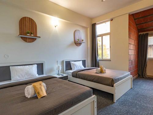 a bedroom with two beds and a window at Z Stays, Silkboard in Bangalore