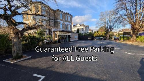 a street with a house with the words guaranteed free parking for all guests at Applewood Hotel in Bournemouth
