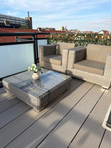 a patio with two chairs and a table on a roof at Studio Casa Martine in Noordwijk aan Zee