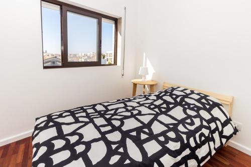 a bedroom with a black and white bed and a window at Guest H4U Povoa Vacation City center in Póvoa de Varzim
