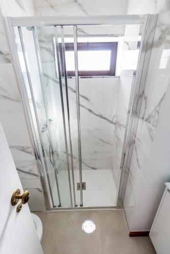 a shower with a glass door in a bathroom at Guest H4U Povoa Vacation City center in Póvoa de Varzim