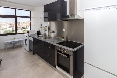 a kitchen with black cabinets and a sink at Guest H4U Povoa Vacation City center in Póvoa de Varzim