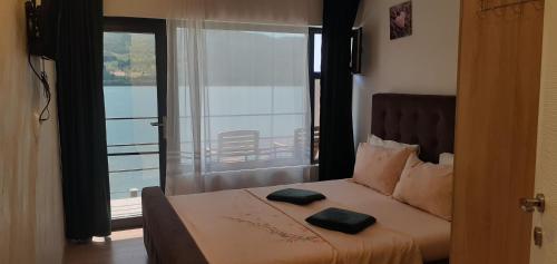 a bedroom with a bed with two pillows on it at Cazanele Dunarii "La Cumatru" in Dubova