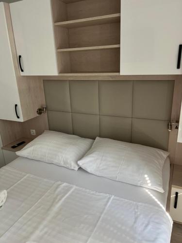 a bed with two white pillows in a room at Sealodge Novigrad Number 18 in Novigrad Istria