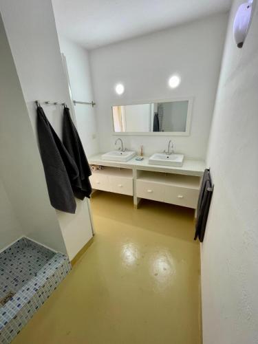 a bathroom with two sinks and a mirror at Surf House Casa Vehla in Sal Rei
