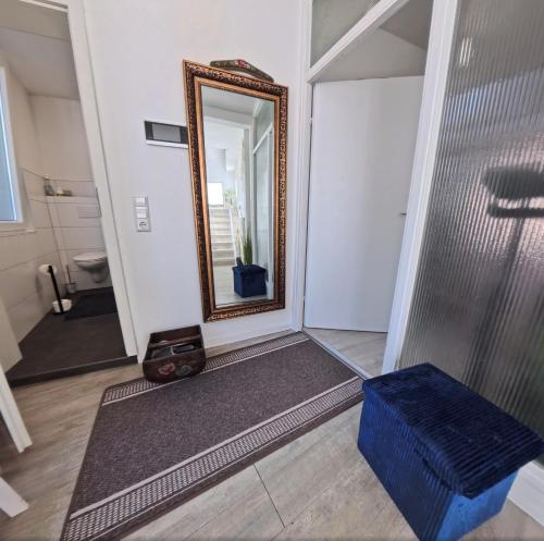 a bathroom with a mirror and a blue stool at Stadtmitte Apartment im historischen Viertel -100qm Wohnfläche & 30qm Dachterrasse in Schwäbisch Gmünd