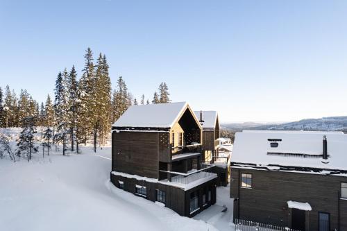 a cabin in the snow with snow covered trees at Ljungvind Kåvan - Funäsdalen in Funäsdalen