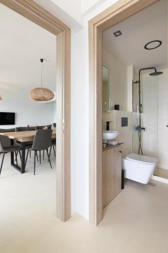 a bathroom with a sink and a toilet and a table at Euphoria Mare in Néa Palátia