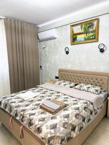 a bedroom with a bed with a picture on the wall at Apartaments Parking Taxi in Chişinău