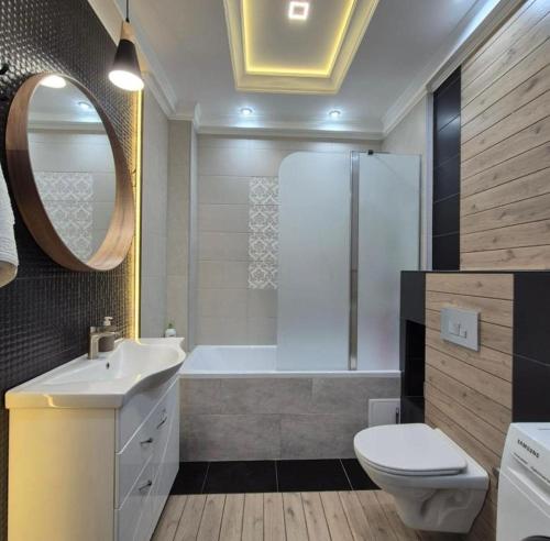 a bathroom with a tub and a toilet and a sink at Apartaments Parking Taxi in Chişinău