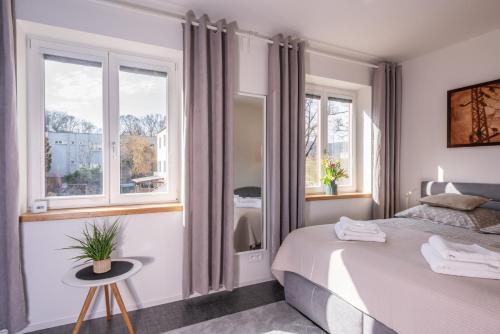 a bedroom with a bed and two windows at Kolonie Apartments in Žabovřesky