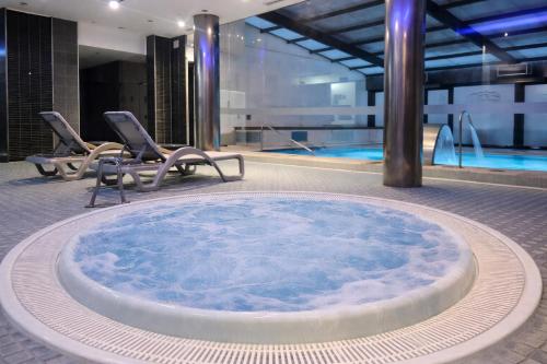 ein Whirlpool vor einem Swimmingpool in der Unterkunft ARVA Spa París in León