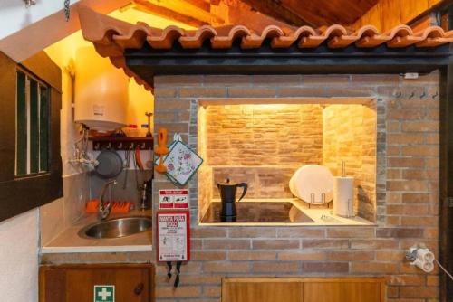 a kitchen with a sink and a brick wall at Casa Fernandes by Mth in Ribeira Brava