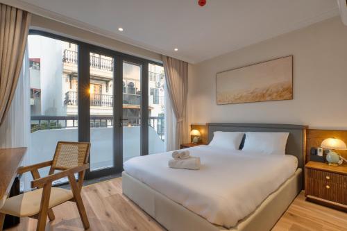 a bedroom with a bed and a chair and a window at Home en Lagom in Hanoi