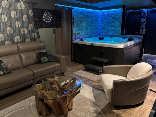 a living room with a tub with a couch and a table at Taelia spa in Rosult