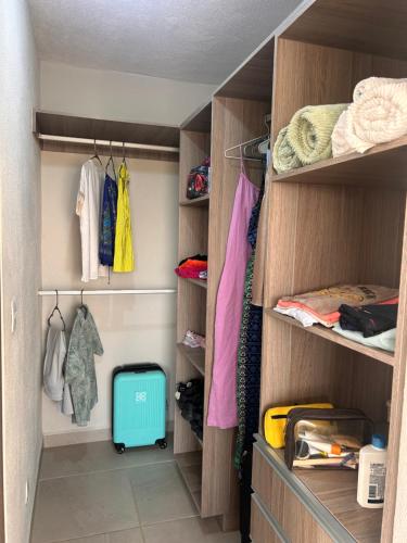 a walk in closet with wooden cabinets and a blue suitcase at New Modern Acapulco Diamante House Getaway with Pool View and Beach Club in Acapulco