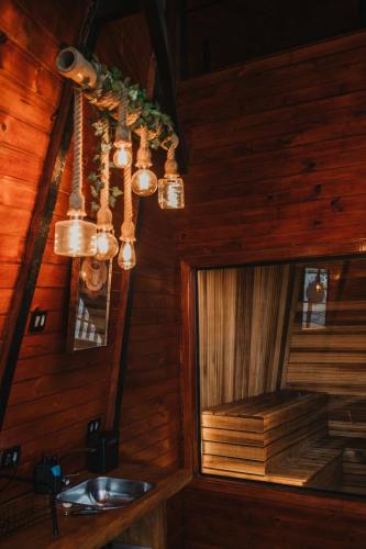 a bathroom with a sink and a chandelier at Chalé Boutique- Spa Campos do Jordão in Campos do Jordão