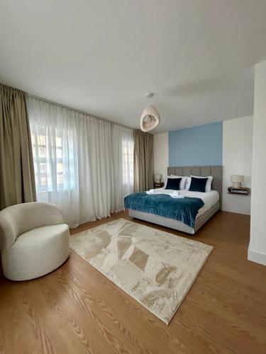 a bedroom with a bed and a chair at Aquae Flaviae Urban Stay - Duplex in Chaves