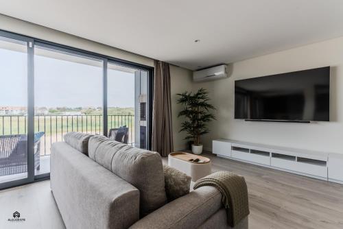 a living room with a couch and a flat screen tv at Shore Apartments - Santa Cruz in Santa Cruz