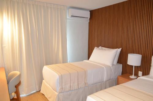 a hotel room with two beds and a window at Hotel Raices del Arapey in Termas del Arapey