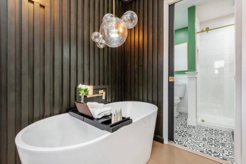 a bathroom with a white tub and a chandelier at Indoor Pool Poconos Retreat with Arcade in Lake Ariel