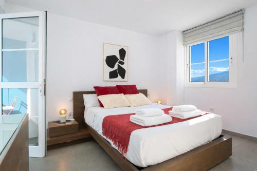 a bedroom with a large bed with red and white pillows at Profithome - Tabaiba Tenerife in Santa Cruz de Tenerife