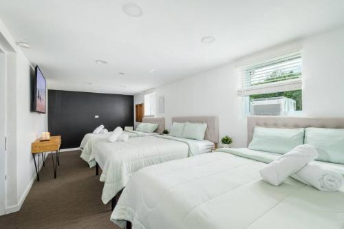 a bedroom with three beds with white sheets at Indoor Pool Poconos Retreat with Arcade in Lake Ariel