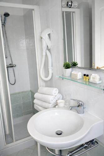 a white bathroom with a sink and a shower at Residence Hotel Claudia in Alba Adriatica